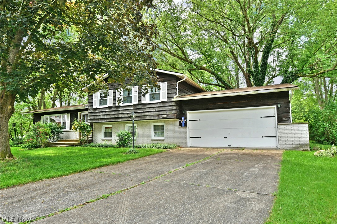 Have you been craving that cozy, down-home style and serenity? Find everything you want and more with this beautifully kept 4 bedroom, 2 full bath Champion Township split level, offering four floors of finished living space and all the character you can ask for! Located on a quiet cul-de-sac off of a desirable side street, the home hides behind the natural cover of tall trees, casting a cool shade across the yard. The unique stained wood siding brings a log cabin feel as a contrasting brick accent wall leads up to the front door. Inside, a slate foyer transcends a shot hall, leading past the main staircases. Meanwhile, a gorgeous living room opens to reveal vaulted ceilings and lush carpets that bask in the natural light of the oversized picture window. The nearby formal dining room offers wonderful backyard views. A central large kitchen highlights custom wood cabinets and a brick accent wall from the fireplace below. Upstairs, three remarkable bedrooms continue their welcoming style as they join a pass-through full bath that ties into the master suite. The spacious master bedroom offers great closet space. The two additional bedrooms are nicely sized with beautiful hardwood floors and private closet space. Down below, the impressive family room is trimmed in rich wood paneling, revealing both a brick fireplace and a must-see sunroom. An additional guest bedroom branches away to join a second full bath with a prominent double vanity. The basement level offers more finished rec space along with laundry and a workshop area that gives access to the backyard. The oversized attached garage offers even more storage space overhead. This home has been well cared for over the years and comes with a one year home warranty.