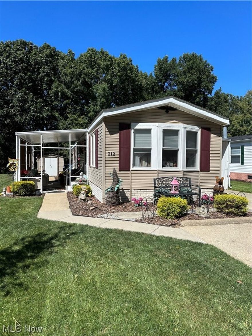 Welcome to 212 F street in the beautiful 55+ Community Navarre village. This 2 bedroom 1 bath home has so many updates done in the last 3 years! Inside you'll find new carpets and sub flooring throughout. Nice front living room. Kitchen has many cupboards, drawers, and even a pantry with plenty of workspace. Eat in dining area. The large bathroom has a new sink, toilet, and exhaust fan. Walk in shower. Laundry area has brand new washer and dryer. 2 good sized bedrooms. Outside you'll find a great enclosed patio with new custom vinyl panels & shade blinds to enjoy the large lot. F street is the desired back street and allows you to enjoy the peaceful surrounding woods, and scenery around the large lot with a shed! The long carport has room for 2 cars, with new removable custom vinyl panels to help keep away leaves & other debris. 2/3 more additional parking spots as well as access to the villages' front fenced in parking lot. New roof, windows, furnace, and AC unit (2021). New hot water tank (2022). Other updates include window awning (being installed this month), range exhaust hood, front door, storm door, shutters, insulated blinds, new water shut off valve, main water pipe with heat tape insulation & more! Motivated sellers! Immediate possession.