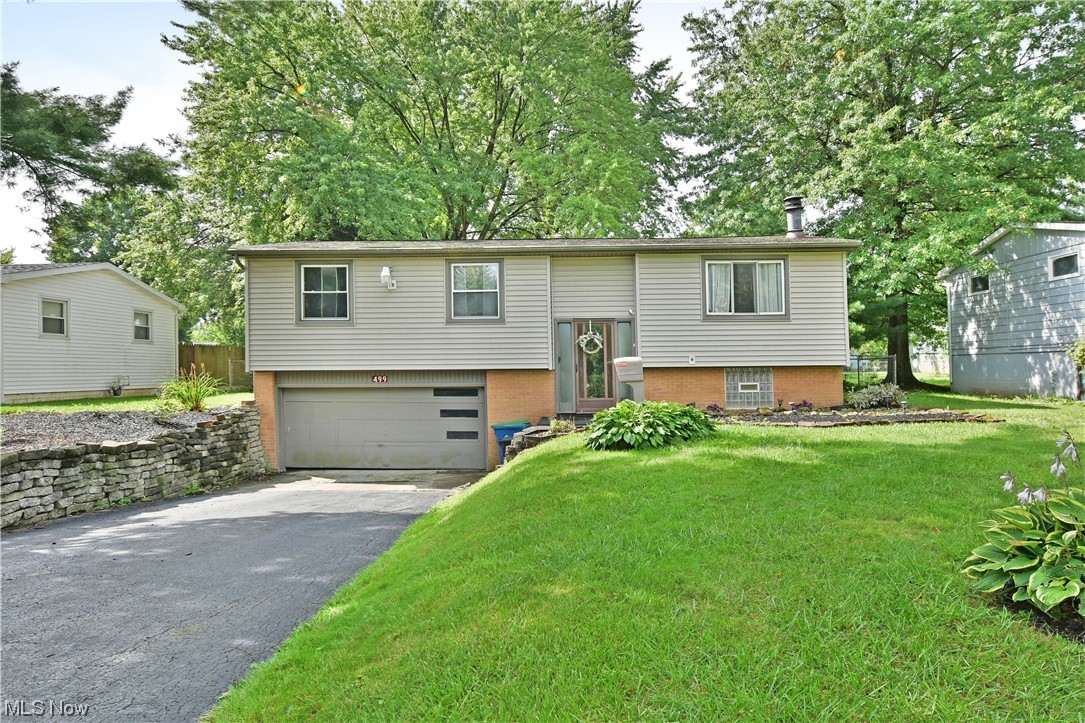 Don’t miss your chance at this charming Liberty Township bi-level! The attractive residence beckons you near with its natural color scheme paired with warm lower brickwork and stone-laid landscaping. Inside, the tiled-like foyer presents a stained wood staircase leading up to the main floor. Here, a carpeted living room showcases its brick-trimmed wood-burning fireplace as a large picture window spills sunshine across the open layout. Nearby, casual dining awaits along with a wood-trimmed kitchen and its bright, stainless appliances that are staying paired with butcher’s block styled countertops. A rear sunroom offers plenty of potential as you enjoy backyard views. Down the main hall, a full bath has been treated to stylish modern updates and sits just before the trio of carpeted bedrooms. The spacious master bedroom offers great closet space and the two additional bedrooms are nicely sized with private closet space and overhead light fixtures. At the lower level, you will find access to the attached 2-car garage and a brightly lit rec space just waiting for your personal touch. The large utility room offers a half bath and is joined by laundry services with the washer and dryer staying. Additional features and updates include a fenced-in backyard with a storage shed, vinyl replacement windows, a new roof in 2012, plus a one-year home warranty!