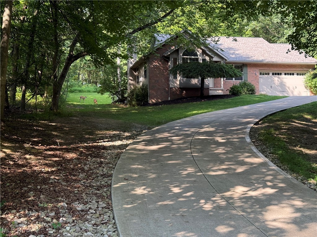 This lovely Ranch Home featuring an Open Floorplan w/ 3 bedrooms & 2 Full Baths on the main floor plus a large Recreation Room w Wood Burning Stove, Bedroom, & Full Bath on the lower level is located just a 1/2 mile from the Main Boat Launch & 3/4 miles from the Main Beach. This one owner home has been Lovingly Updated and Cared For. Recent updates include a Brand New Roof August 1 2025, Basement Bedroom carpeted in July 2025, Nice vinyl flooring through Most of the House and basement Rec Room spring of 2025. New kitchen countertops were put in August 2025 and the entire Interior was Freshly Painted 2025. As you walk through the front door, you are Embraced by High Ceilings, Natural Light, & an Open Floor Plan where you immediately are greeted by the living room, dining room and kitchen. Living room features tall vaulted ceilings, a beautiful Propane Fireplace with a large television mounted to the wall above it, new stylish ceiling, fan, and large breathtaking front window ... Round Top Palladium Style. The dining room which is open to the living room and the kitchen has a large sliding glass door opening out onto the private deck and also has wonderful views of the very private backyard where adorable dear families visit nearly daily. The well appointed kitchen which overlook the living room and dining room, features quality, stainless steel appliances and brand new countertops and garbage disposal. There’s a large pantry a step away from the kitchen. There is a first floor master suite with en suite bath and a large walk-in closet. There are 2 more bedrooms and a full bath along with a nice laundry room. that complete the first floor. The garage is a 2-1/2 car garage extra deep it’s 560 ft.². The very nicely finished lower level features a 26x16 rec room with a wood-burning fireplace, 10 x 12 office/bedroom with adjacent full bath. There also is a very spacious storage area in the basement. The lot is a very private 8/10ths of an acre. This home is Move-In ready.