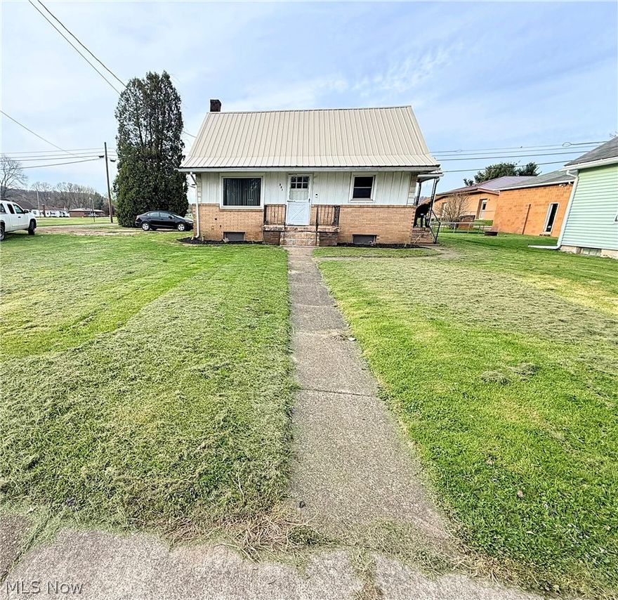 Quaint, updated bungalow blending charm with modern touches. The refreshed kitchen features wood-look LVT flooring, painted cabinetry, new backsplash, countertop and wainscoting. The living room offers exposed hardwoods and a custom pallet accent wall. Main-level bedroom also features hardwood flooring. The dining room with exposed wood flooring, and spacious built-ins.  Upstairs includes a second bedroom and loft with a custom built-in desk. Freshly painted throughout.  The finished lower level is ideal for entertaining with a full bath, shower, laundry, storage, and exterior access. A spacious breezeway connects to the attached one-car garage. Additional highlights include geothermal heating and cooling, vinyl and brick exterior, metal roof, covered front and side porches, and a one-year home warranty.