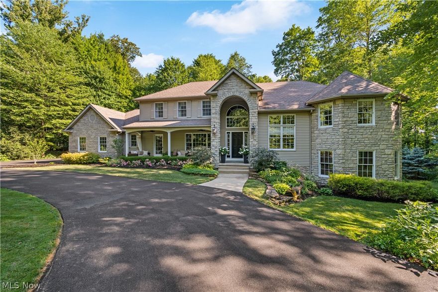 South-facing, one of a kind split-level home w elevator, enveloped by exquisite landscaping & 2.5 private wooded acres. Repaved circular drive leads to inviting 6’ deep front porch. Dramatic 2-story foyer w hardwood floors, extensive trim, & switchback stairs is flanked by a formal dining room w wainscoting, & a study w glass-paned French doors & volume ceiling. Great room boasts 11’ ceilings, large windows & striking floor-to-ceiling stone fireplace. Spacious renovated kitchen has wood floors, granite countertops, coffee bar, center island w seating, subway tile backsplash, wall oven/microwave, pantry, & dinette area w slider access to back patio. Down the hall is a laundry room, half bath, porch access. Stairs from foyer or great room lead down to half level w bayed rec room, 2nd office, & cozy pub room w cherry L-shaped wet bar–each room w walkout access! Heading upstairs to the first landing is the vaulted master retreat w bay window, linen closet & en-suite bath offering walk-in c