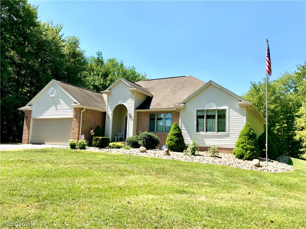This beautiful brick-and-vinyl ranch is a rare find: a country setting with a gorgeous, expansive view of the valley between Ohio and Pennsylvania. Sitting on three acres -- half cleared, half still timbered with mature trees -- this spacious two-bedroom, two and a half-bath home has a master bath en suite, a main-floor laundry, a kitchen/dining area that leads to a large concrete patio overlooking the back acres. There are solar lights on the patio rail posts. The living room has a tray ceiling and corner fireplace. Do not mistake the tile flooring in the front foyer, bathrooms, and kitchen for ceramic. It is porcelain -- made from a finer clay making it denser and able to withstand outdoor conditions. Both the attached and back garages are wired for 220 lines. There is a waterline outside of the back garage. The attached garage has a wheelchair ramp and still provides room for two vehicles. The seller owns the 500 gallon LP fuel tank used to heat the home -- reducing costs considerab