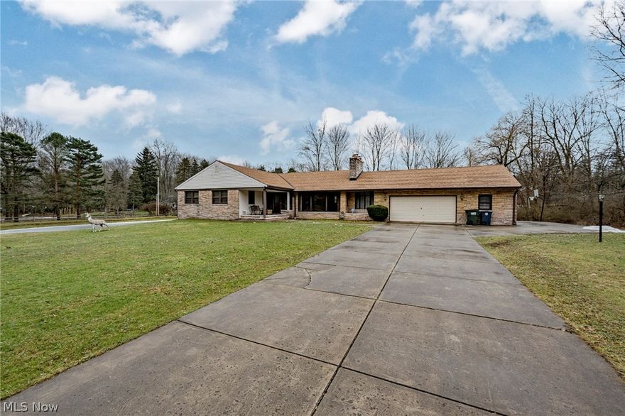 Welcome home to this magnificent mid-century modern ranch style home on a pristine 1.5-acre homesite in Orange! This exceptional home provides over 4,000 square feet of living space with vaulted ceilings and large windows throughout. A covered front porch opens to the foyer. From the moment you step inside, you will know you are someplace special. The great room is the heart of the home, and features an impressive stone fireplace, a vaulted, beamed ceiling, and a wall of windows that welcomes natural light. A dining area connects to a charming breezeway with a grill, where sliders open out to the back patio and yard. The kitchen includes a breakfast bar and a sunny eat-in area. There are four bedrooms and 2.5 bathrooms on the first floor, including the owner's suite. Two bedrooms have access to a lovely covered side porch that overlooks the pond, so you can relax and enjoy the sunrise in the morning. The full lower level includes a large rec room with ground level windows, the fifth be