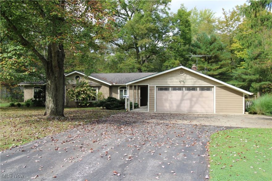 Who doesn't love a charming 1959 ranch nestled on 1.5 lush, wooded acres in the heart of Bainbridge Township, Kenston Schools? This 3-bedroom, 1.5-bath home offers a rare blend of mid-century character and modern comfort. The interior is waiting for your personal touches and decorating ideas. The vaulted ceiling in the family room addition with its prominent wood burning fireplace and mantle could be your spot to decompress after a hard day's work.  Freshly painted in 2024, the exterior is well maintained.  It has a quaint front porch area, but the peaceful views from the enclosed rear porch complete with a hot tub and wood burner, are a site to be seen. Step out onto the deck that runs the length of the enclosed porch to entertain or be surrounded by nature. The property features a heated and air conditioned 32x21 outbuilding that was constructed with a concrete floor with 2" high density foam and 4" of stone for added warmth, a 220 line, a garage bay door, and a porch with lean-to —perfect for a workshop, studio, mancave, she-shed, or extra storage—plus a 10x10 shed for added convenience for your gardening tools etc.  A whole-home gas generator is the "cherry on top" and ensures peace of mind year-round. Don’t miss this private retreat just minutes from downtown Chagrin Falls and the many conveniences it offers!