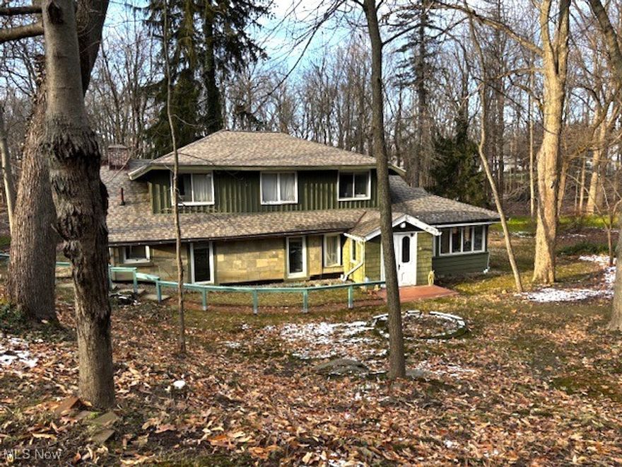 This is not a cookie cutter home, if you want a unique home this is it.  The home sits below the street and the 2-car garage is a street level.  Your back yard is Euclid Creek, and part (maybe all) of the property is in flood zone. Once the vestibule door is opened into the spacious 18x23 living room, you will see the gorgeous red brick woodburning fireplace, as you look to your right you will find the 21x8 office/sitting room with a lengthy panoramic view of the side yard and trees, going 2 steps you will find the eclectic 27x17 eat-in kitchen with glass views to 2 sides.   In addition to the rooms mentioned before, the first floor has 2 bedrooms with many built-ins and 2 baths and a laundry room. It looks as though the second floor was originally built for relatives as it has its own kitchen, bath, bedrooms and a great bonus room.  Bring your own special touches and make this house into your HOME.  The home comes with its own power generator.  There will be a house sale of contents on March 21-22 when the contents of the home will be sold.