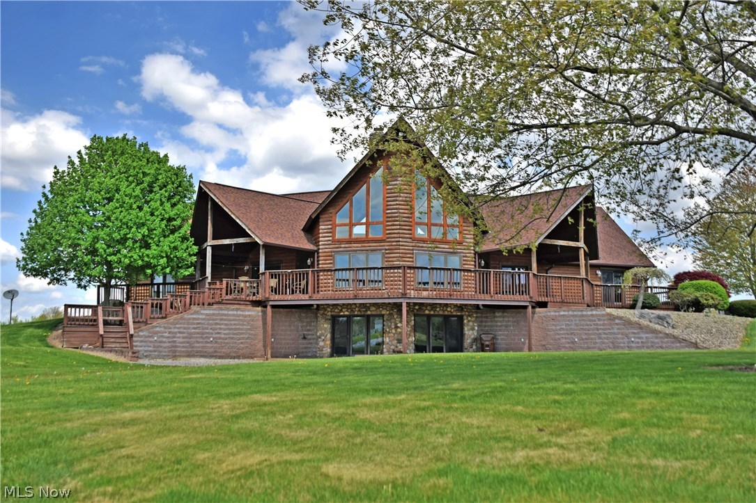 A property like no other. Prepared to be blown away by this visual masterclass of a log cabin home, set on a property unlike any you’ve seen before! The visuals are breath taking and the numbers are staggering. Over 30 acres of land, two lakes, five bedrooms, three floors of unique living space, combined garage space for up to nine vehicles, a huge shop with extended bay and door areas with drive through semi access. When they say, ‘this has it all’, this one means it. Breathtaking indoor views are had from each tier of the home as tall glass windows span two floor and a walk out basement to showcase the manmade lake. Stunning woodwork fills each room, covering both walls and ceiling to create rooms that burst with personality, style and natural feel. Focal points of design include a three story all stone chimney with tri level fireplace areas, a spiral staircase with steps formed from full sized trees, and a wrapping, extended rear patio for taking it all in. The home maintains an ope