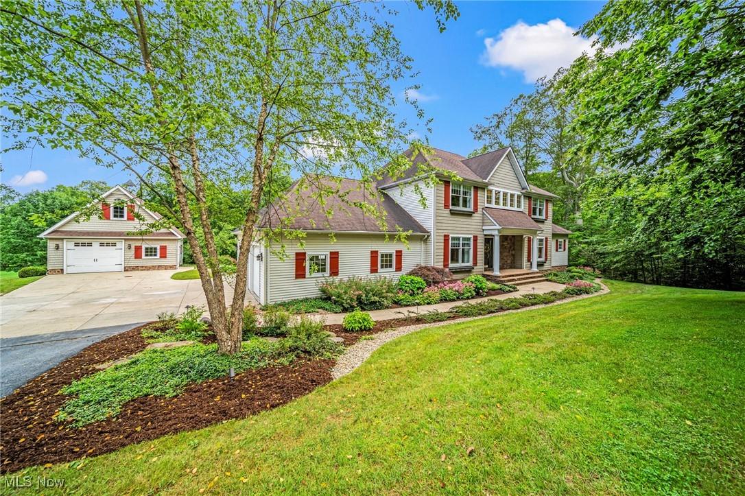 Welcome to this beautifully maintained open concept, custom built colonial, bordering Chardon Lakes Golf course on the outskirts of Chardon. Nestled on a peaceful 2.72-acre lot in Munson Twp, this property offers exceptional features both inside and out. Step into the inviting foyer and take in the beauty of the natural woodwork and well lit interior. The impressive great room features a wall of windows, coffered ceilings, and built-in cabinetry with dry bar that surrounds the gas log fireplace, perfect for relaxing or entertaining. The eat-in kitchen boasts updated appliances, granite countertops with counter seating, and ample space for cooking and gathering while offering access to the beautiful back yard and upper deck with outdoor dining area. A stunning wood-paneled library/study with coffered ceilings provides a quiet retreat for work or reading, while the formal dining room sets the stage for elegant dinners. The spacious first floor owner’s suite is a private oasis. An arched hallway flanked by walk-in closets leads to the luxury bath with dual vanities, jetted tub and walk-in shower. Upstairs you will find 3 large bedrooms with ample closet space and 2 full baths. The finished walk-out lower level is an entertainer’s paradise! Enjoy a spacious Rec room, Game room, and Media room, perfect for movie nights, game days, or hosting friends and family in style. Enjoy the outdoors in the professionally landscaped yard with a stone patio with built-in lighting and gas fire pit, perfect for fire-pitting with friends. The property also includes an additional detached, heated dual level garage/barn with loft for hobbies, storage, or workshop space. Just minutes from historic downtown Chardon, this home offers the privacy and space of country living with convenient access to local shops, schools, and parks. Don’t miss this rare opportunity!
