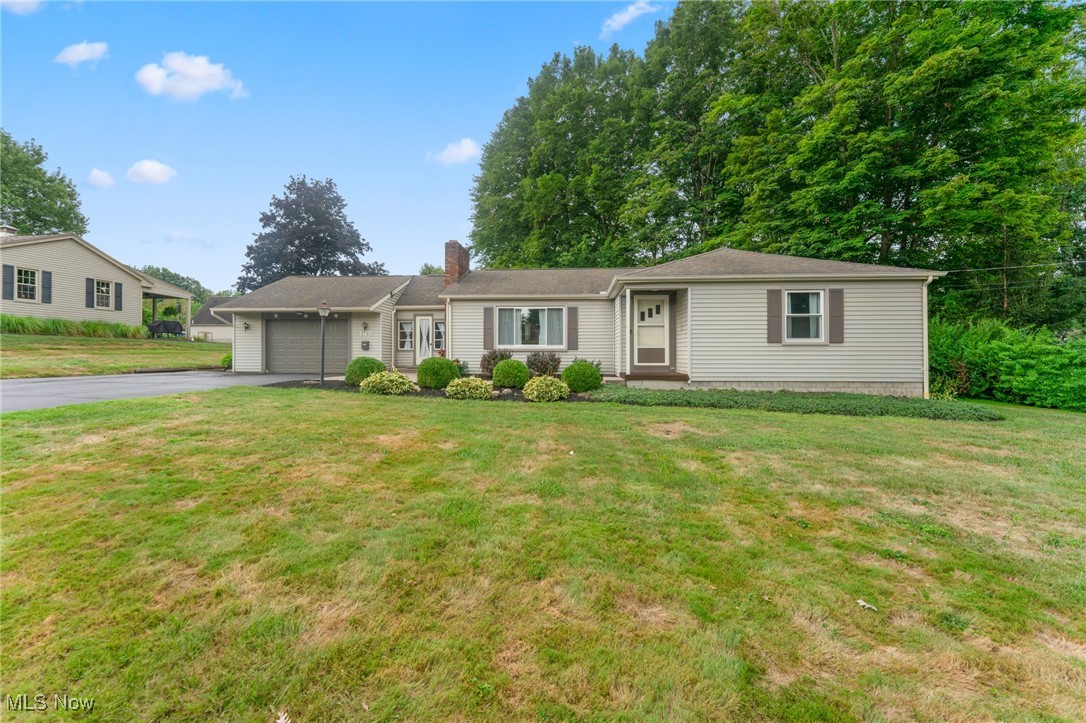 Discover this charming ranch-style home at 145 Belle Vista Ave, Hubbard, Ohio, offering over 1,300 sq. ft. of comfortable living space with 3 bedrooms and 2 full bathrooms. Situated on a spacious half-acre lot, there’s plenty of room for outdoor activities, pets, or gardening. Step inside to a large living room with coved ceilings, fresh carpet, and a cozy fireplace. The adjoining dining room features hardwood floors, updated fixtures, and coved ceilings, adding a touch of timeless character. The home boasts new vinyl windows throughout, bringing in plenty of natural light. The kitchen offers wood cabinetry, laminate countertops, vinyl plank flooring, and ample space for meal prep, with direct access to the back deck, brick patio, and storage shed. All three main-floor bedrooms showcase hardwood floors and large double closets. The full bathroom is updated with a new vanity, porcelain tub, tile walls, and vinyl plank flooring. The basement provides abundant storage, a dedicated laundry area with a convenient laundry chute, a full bath with walk-in shower, and an additional room perfect for finishing or extra storage. A breezeway with wood paneling and new vinyl flooring connects the home to the attached 2-car garage. Mechanical updates include a newer 100-amp panel, high-efficiency furnace and AC, dimensional shingle roof, vinyl siding, and fresh paint throughout. Located in the desirable Hubbard School District, this move-in-ready home blends classic charm with modern updates.