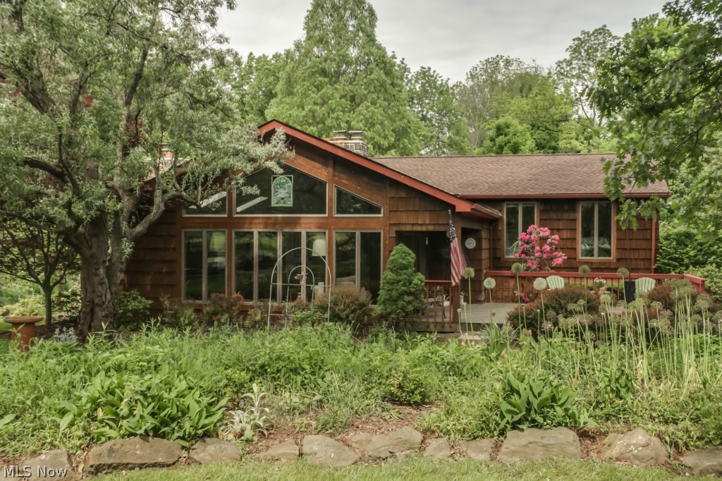 Enjoy all 4 seasons, and sunrises and sunsets from the Master Bedroom. The gas or wood fireplaces, plus a wood stove allow alternate heat and fun on all 3 major levels. Walk out to the large stone patio and wooded garden-filled back yard and enjoy the unexpected privacy of being on over 1 acre of land. The kitchen has been updated with a modern spin on an industrial setup and will surpass your entertaining needs. The 2 car attached and heated garage make winter mornings delightful. The 2 and a half car detached garage and concrete pad adds additional living space, as well as the original single car garage = 5 1/2 garage spaces!