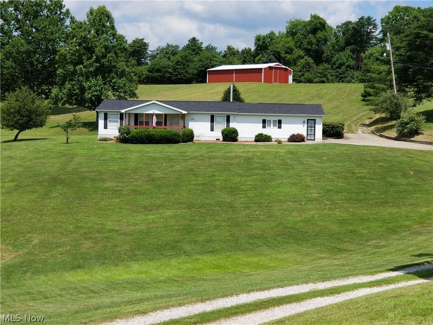 This 2 bedroom 2 full bath manufactured home has been updated with numerous improvements during the past 18 mos. It is better than new. Home has vaulted ceilings and great room has gas fireplace with oak mantel. All main living areas has new 100% waterproof Pewter Oak Outlast Pergo with a 25 year warranty and other improvements include all new stainless appliances, new backsplash, all new paint throughout, nice oak cabinets, new custom wainscoting in great room and new baseboard. White 6-panel doors add to the bright cheery setting. Bedrooms have new carpet. Master has a private master bath and walk in closet.  Home has 200 amp electric and  new roof. The attached oversized garage is 27x28.  There is a 30x50 pole barn with a new 6" thick concrete floor that sits behind the house and a 90x14 concrete pad at the beginning of drive for an RV or another storage building. New a/c unit  2015. If you want to live in the country with the beautiful scenery and space but be less than 10 minutes