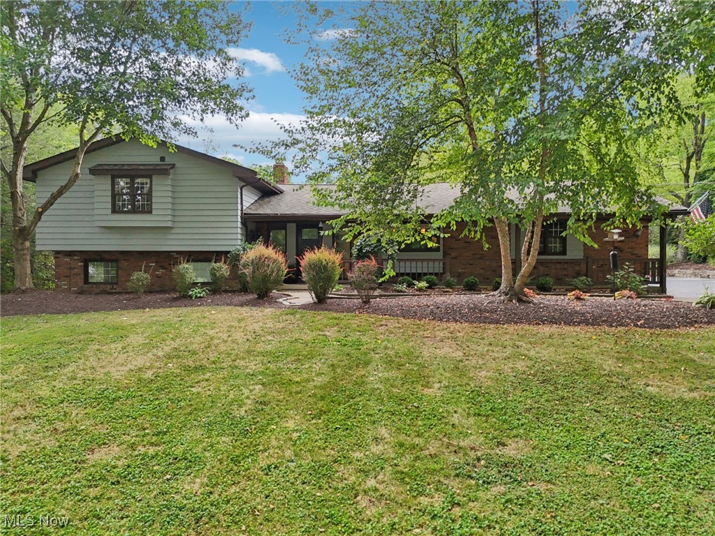 Showstopper! Russell Township! Beautifully maintained 4-bedroom, 2.5-bath home set on a serene lot with updates throughout. Light-filled foyer entry. The main floor features a fully renovated kitchen with espresso wood cabinetry, granite counters, high-end S/S appliances, peninsula into the dining room, and a large island overlooking the front porch into the lovely front yard. The kitchen flows into the dining area where both living and dining room offer views onto the enclosed sunroom. Convenient main floor laundry! The spacious primary suite offers a custom-organized walk-in closet and en suite bath with shower. Three bedrooms are just steps up from the main level, while the lower-level 4th bedroom is currently used as a convenient office. The lower level provides additional living space with a family room with built-ins and fireplace and sliders to the incredible hardscaped patio with gardens framed by mature trees. The enclosed sunroom with a wood-burning fireplace and hot tub spa also opens outdoors, creating seamless indoor-outdoor living. This property boasts numerous recent updates—full list available upon request (see attached PDF). A brand-new concrete driveway leads to an impressive outbuilding that truly must be seen in person, offering endless possibilities for use. Perfectly situated in a prime location, this turnkey home is truly one-of-a-kind.