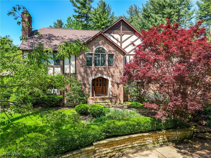 Stately Tudor Home in The Sanctuary of Bath! Private 1.01 acre wooded lot | ~5887 sq ft | 6 BR | 5.5 BA | 3 Beautifully Finished Levels. Enter the 2-sty foyer w/curved stair, flanked by formal LR & DR featuring HDWD flrs, crown molding, inviting fireplace, large walk in closet and powder room. Spacious family room boasts wood-beamed ceiling & a 2nd brick fireplace, flowing into a study w/custom Blt Ins & a beaut sun rm w/walls of windows pulling in the sunlight & FRdoor accessing the expansive deck with enclosed gazebo overlooking the serene bkyard. The oversized, centrally loc’d KIT offers abundant cabinet space, granite countertops, convenient wet bar, blt in desk, all high end appliances (under 10 yrs) include 2 dishwashers, warming drawer, microwave, 5 burner gas stove, bayed/windowed dinette w/sliding doors that access the back deck, lg island w/bkfst bar, awesome walk in pantry & more! A full BA serves the loft/5th BR. Wonderful laundry rm w/even "more" cabinets, working counter space, closet and freezer that remains with the home completes the 1st fl. Upstairs is the luxurious owner’s ste w/bayed sitting area, WIC, dbl vanity, spa tub & separate shower. 3 generously sized BRs & 2 full BAs. wrap up the 2nd floor. The walkout Lower Level impresses w/wood-look flrs and full-size windows. Enjoy the 3rd fireplace in the spacious fam rm, additional flex space/rec/game rm w/FRdoors to private patio and beautifully maintained gardens w/irrigation sys. The 6th BR & 5th full BA complete the lower level. Some updates incl. newer roof (2018), HVAC, H2O  tank (2017) , kit appliances (<10 years), dinette windows/sliding door (<10 yrs), 1st fl shower/granite (<10 years) & more! Plumbing for central vac. Home warranty included!