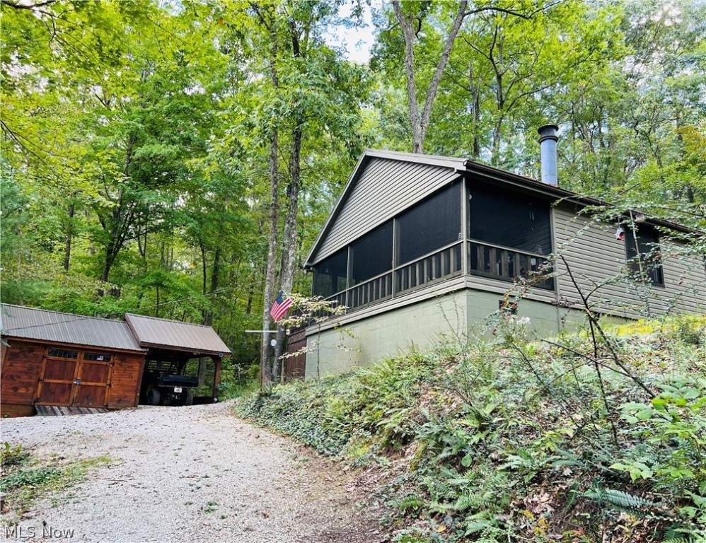 Enjoy year-round Lake Life in this adorable lake view cottage at beautiful 2270 acre Piedmont Lake. This two bedroom, one bath, well-maintained lake cottage is only steps away from your own private dock in the MWCD Hilltop Community. Enjoy limited summer lake views and more open fall and winter views and spectacular sunsets from the screened porch. The property has great outdoor spaces to enjoy entertaining family and friends whether you are socializing around the fire or enjoying the projector area with outdoor speakers in the pavilion. Charmingly decorated and updated, the fully insulated home has ample heat and cooling for year-round comfort. In addition to the wood burning stove, the cottage has a new HVSC/mini-split units (heating and cooling) and baseboard heaters for an additional heat source. New windows were installed in 2017 and the lifetime warranty will transfer to the new owners with a minimal fee within 30 days of sale. The beautiful community docking area is just minute
