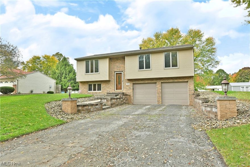 Fall in love with the thoughtful updates and quality craftsmanship of this recently updated Lordstown bi-level home! Take in the manicured stone landscaping and tiered cement walkway awash in the morning sun or embrace the captivating exterior lighting that puts the residence on showcase at night. A decorative entry door opens to the main stairway as lush carpets rise from the tiled foyer. Stained wood railing adds to the allure. A gracious living room takes full advantage of the three-pane picture window, spilling natural light across the soothing, off-white walls. The nearby dining room continues to illuminate with its sliding door and wrapping chair rail. Marbled-look flooring cuts away into the engaging kitchen where a tiled backsplash runs between the piano black appliances and stone-look countertops. Down the main hall, a lavish full bath delights with a whirlpool tub and striking gold and marble work. The trio of bedrooms includes an oversized master with scenic backyard views. The two additional bedrooms are nicely sized and offer private closet space. Down below, the basement level is complete with a spacious and cozy family room w/ its corner fireplace. A 2nd full bath hides away near the hidden laundry & utility access. The painted and sealed attached two-car garage includes hot and cold-water hookups. Updates include: brand new sliding glass door to be installed prior to closing, AC 2022, HWT 2016, renovated baths 2023, and so much more plus a 1 yr home warranty!