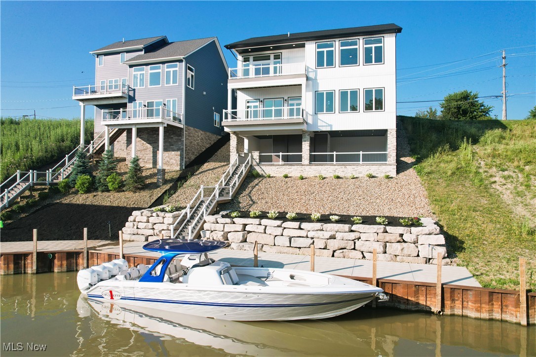 Vincent Homes has done it again. This breathtaking masterpiece of a home is perched high above the Chagrin River and is the epitome of luxury lake living. This titanic home boasts 3 levels, an open-air basement veranda, and a 60' boat dock. The design and detail are simply beyond compare. Interior features include a 2-car garage, rotunda front office, large open concept kitchen / living room, two laundry options, two primary suite options, high ceilings and views on every level, beautifully tiled bathrooms with modern fixtures, a primary closet boasting twin chandeliers, the list goes on. You will be blown away at the open air 'basement' entertaining area, it is like something you see in movies! The Chagrin River is the new place to be with dockside restaurants including Trader Joes, The Deck, and the new Chagrin Tavern and Castaways Tiki Bar. Take your boat out for dinner or a cruise on Lake Erie. Take your kayaks or dinghy up the river to the cascading water at Chagrin River Park or to your favorite beach or watering hole. The path of progress is taking this area by storm and 23 new luxury building lots (with docks) will soon be sold just down the street (you can see this new project location in drone photo #7). The savvy buyer will recognize that capitalizing on this home now will be a solid investment to make before the area catches fire with more new construction. Walk, dinghy, or golf cart to watch live bands playing all summer long at the two new restaurants below. Save on yacht club costs and live right on the water with your boat at your back door. Coffee person!? A new Dunkin is next door! Think of the gatherings you could host on that lower level; Your friends can come by boat! Luxury new construction homes of this caliper with 60' of dockage rarely appear on the market anywhere in Ohio east of Cleveland. One buyer will have the opportunity to secure this showpiece. Schedule your showing today and start living lake life tomorrow.