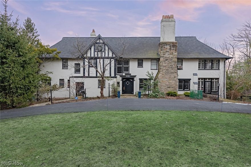 Fall in love with this exquisite English Tudor on the most serene lot in South Euclid! Situated on a park-like 4+ acre lot, this magnificent home features a gracious floorplan and fabulous backyard oasis, perfect for indoor and outdoor entertaining! As you step inside, you will immediately appreciate the intricate millwork and gleaming hardwood floors that flow through the main level. The living room features a classic fireplace, large windows, and glass doors that open to a gorgeous sunroom. The formal dining room steps out to the patio and features panoramic views of the gardens outside. The updated kitchen includes a lovely butlers pantry, stainless steel appliances, and a sunny eat-in area. Two half bathrooms, a mudroom, and a stunning family room with a fireplace and vista views of the gardens completes the first floor. Upstairs, you will find five bedroom suites, including a private master suite with a gorgeous bonus room, plus a convenient second floor laundry room. The third floor provides three additional rooms, perfect for a studio, a full bathroom, and ample storage. Outside, the in-ground pool is surrounded by a multi-tier stone patio and lush greenery, providing peace and privacy, plus there is a 4-car garage and a greenhouse. Located on a serenely wooded lot abutting Mayfield Sand Ridge Club, this home provides privacy without sacrificing convenience. It is just minutes from area shopping and dining. Do not miss your chance to own this exceptional home!