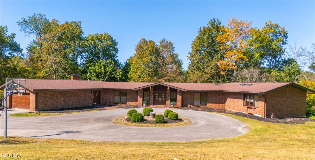 Welcome to this stunning brick ranch home nestled among mature trees with serene pond views, circular driveway and 2 front entries! The beautiful approach along Country Club Road, bordered by the golf course and lake, leads to this 3 bedroom, 3.5 bath residence with exceptional curb appeal. The double front door entry greets your guests into the open floor plan living room to the dining room with beautiful chandelier and large windows. The spacious eat in kitchen is complete with appliances, abundant cabinetry and large walk in pantry. Flow seamlessly into the family room with a cozy fireplace. Step outside to the wrap-around deck to enjoy views of nature and refreshing breezes. The primary bedroom is large, well lit with walk-in closet and walkout to the deck. You will love the spacious full bath with soaker tub and shower. A second primary bedroom is a plus with a full bath and walk-in closet. Third bedroom is currently used as an office. Laundry closet including appliances is located conveniently near the bedrooms. The private treed backyard is the ultimate entertaining area with 2 decks, patio, gazebo and view of the pond. Huge unfinished basement with full bathroom is perfect for all your storage, exercise equipment and garage space for lawn equipment. The home was painted with neutral colors. Beautiful wood floors, skylights, beamed ceilings, newer roof, basketball pole. Home Warranty!