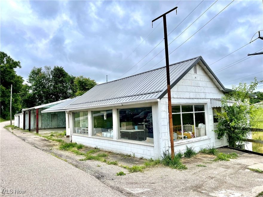 Store front, work shop, 2-3 garages, covered parking area and storage buildings. This property was formerly a repair shop. It is currently being used as storage. Owner had a metal roof installed over store front building in 2021. Per auditor one of the buildings were built in 1959 and another in 1964. The age of garages is unknown. Buildings being sold AS/IS with contents. Mineral Rights will be retained by seller. Power line easement in rear of property.