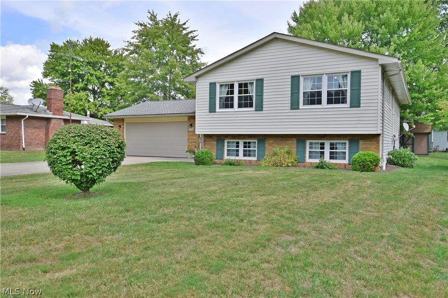 Enjoy the comfort of this comfortable Champion split level; offering three floors of finished living space, each neatly trimmed in rich woodwork and lush carpets. A unique wood panel foyer finds you at the base of both stairway landings. Up to the main floor, a spacious living room is bathed in natural light from large picture windows as the formal dining room wraps the corner. The central kitchen enjoys hardwood style flooring paired with natural finish cabinetry, pairing with white appliances and a stainless sink insert. The main hall passes a robust full bath as you find the three bedrooms. The largest, master suite bestows over-sized closets and its own full private bath with stall shower. Downstairs, relax in an endearing family room; showcased by a center fireplace. Opposite, the rec area opens to reveal both a game room and a lower bath along with a bedroom/bonus room. Laundry is also accessible on this floor. Stairway access to the covered back patio is also available to enjoy