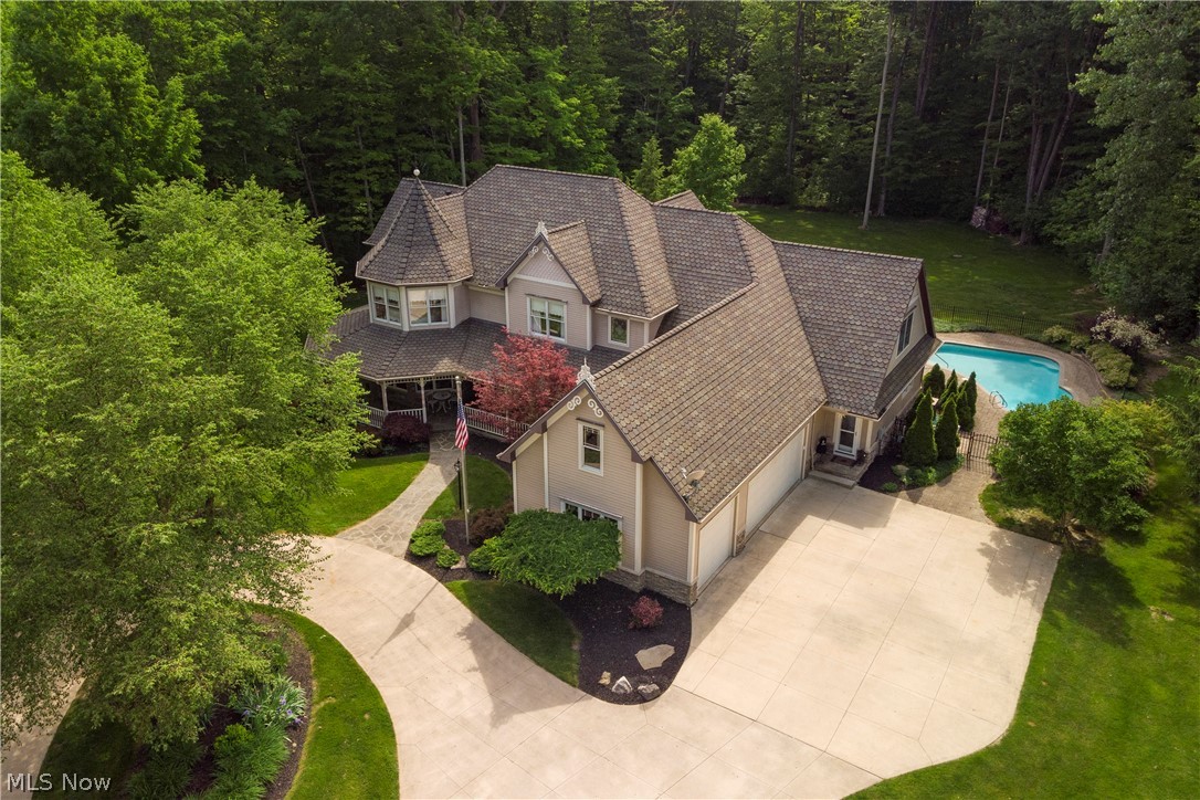 Your own Private Estate! Beautiful turn around drive & professional landscaping greet you. 10’ deep front porch across the complete front of the home and the side of the house. Custom built home with attention to the details. Large Foyer welcomes you w an inlaid design in the solid wood floor. 2-story great room with stacked stone fireplace, built-in shelving & storage on both sides, and a wall of windows. Access to your custom patio and private backyard get-away including a well maintained in-ground pool and hot tub. French doors from the great room to your library w/a wall of built-in bookcases & custom millwork walls. Open Kitchen w/vaulted ceiling, skylights, & access to the back patio. Chefs dream w/double wall ovens, large gas cooktop, walk-in pantry, two dishwashers, granite counters & island, custom cabinetry including a window seat! First floor master w/large sitting area, exterior door, his & her walk-in closets. Master bath with jetted tub, large walk-in shower, & exterior door with a hot tub just steps away. Master bedroom Fireplace is two sided and shared with the large office. Second floor generous loft area. 3 bedrooms upstairs, one with its own private full bath. Solid wood doors & upgrades throughout including 2x6 construction & upgraded insulation! Custom patio across complete back of house with built-in firepit & a water feature including a waterfall and a small pond. 3 car side entry garage. Highly Rated Revere schools. Close access to freeways and parks.