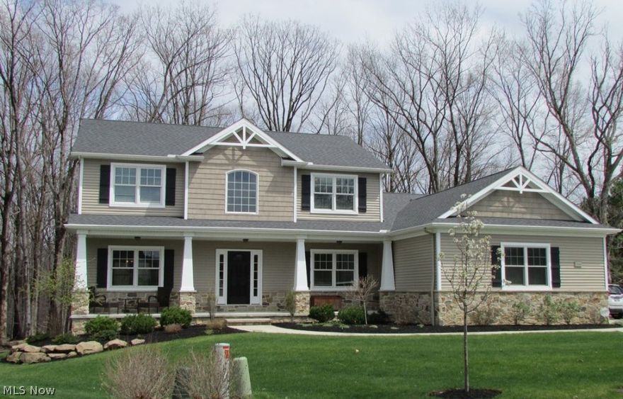 Enjoy a private peaceful wooded lot in Independence.  This four bedroom  three full bath craftsman style colonial has 2914 square feet is practically brand new.  There is potential to add living space with the walk out basement with extra high ceilings that is 1622 square feet and plumbed for full bath.  The kitchen features espresso maple cabinets, granite counters, custom tile backsplash with under cabinet lighting and stainless steel appliances. Entertain in this large kitchen with breakfast bar that leads into an open vaulted family room with fireplace.  The master bedroom also has a vaulted ceiling.  There is also a two story foyer with a beautiful chandelier and wood floors which continue to the kitchen and pantry.  The dining room is large and bright with beautiful white wainscoting. There is also a first floor den and living room.  Professional landscaped with sprinkler system in front and back yards.  The backyard has a composite deck that has steps down to level grass area.