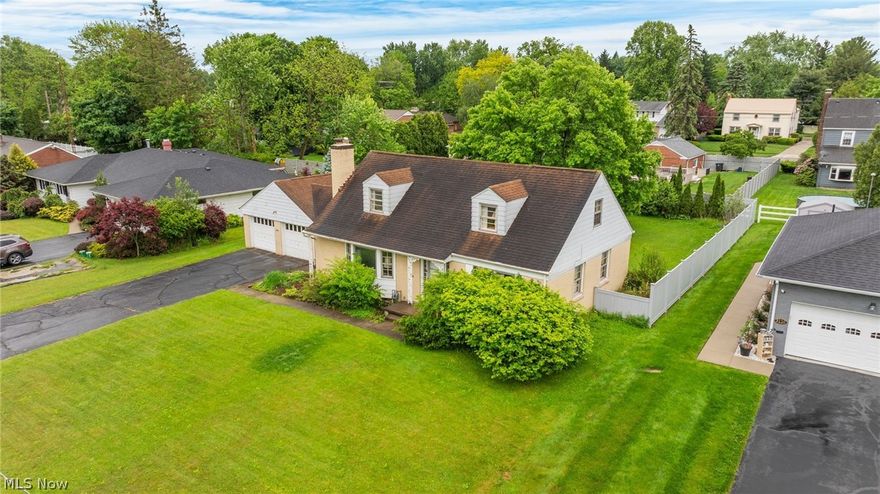 Beautiful old-world Cape Cod nestled in Warren?s desirable Country Club Estates, within walking distance to Trumbull Country Club. Cherished by the same family for over 75 years, this 4-bedroom, 2.5-bath home offers timeless character, generous space, and wonderful potential. Classic hardwood floors flow throughout much of the home, complementing the warm charm of the living room with bay window and wood-burning fireplace. The cheerful kitchen offers ample cabinetry and storage, opening to traditional dining and living spaces. Two bedrooms and a full bath are conveniently located on the first floor, with two additional bedrooms and a full bath upstairs. The enclosed breezeway with knotty pine detail connects to the attached two-car garage. The finished lower level features knotty pine paneling, a wet bar, storage cabinetry, laundry area, workshop space, glass block windows, and an additional half bath. Extensive electrical updates have been made for added peace of mind and safety. Enjoy a spacious backyard with mature landscaping, vinyl fencing, patio space, and three-season color. Central HVAC replaced in 2023. A home warranty is included. A rare opportunity to own a well-loved home in a premier location.