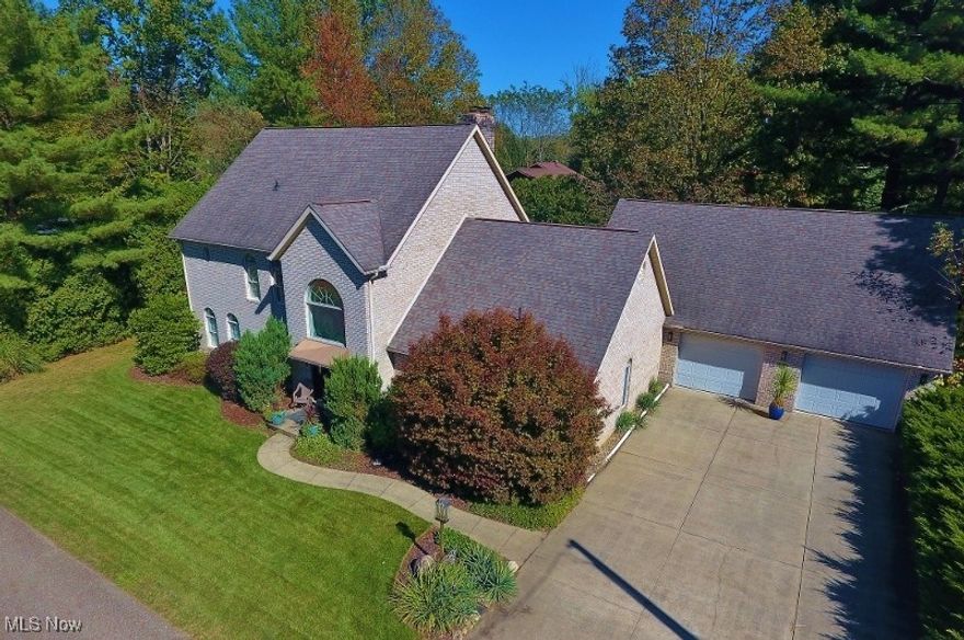 Discover one of Atwood Lake’s most distinguished properties, perfectly situated in a charming neighborhood on private land (no lease). This impressive brick lake view home offers the complete lake lifestyle — including two dock slips for your watercraft, just a short walk from your front door, providing easy access to scenic 1,540-acre Atwood Lake & the community beach. Step through the front door into a grand two-story foyer featuring a beautiful oak staircase. The spacious great room showcases soaring ceilings, a gas fireplace, and a dramatic wall of windows overlooking the custom paver patio. The gourmet kitchen is a dream for any culinary enthusiast, featuring abundant white cabinetry, Corian countertops, a gas cooktop, double wall oven, dual ceramic sinks with prep sink, large pantry, & a convenient eat-at bar. The adjoining dining area makes entertaining effortless. The luxurious primary suite is a true retreat, complete with patio doors opening to the back patio. The spa-like ensuite includes a double vanity, oversized custom-tiled shower, soaking tub, walk-in closet, ceramic flooring, and private water closet. Additional main-level highlights include a dedicated home office, spacious laundry room, & half bath. Designed for relaxation and entertaining, the expansive custom paver patio with firepit is accessible from the great room, primary bedroom, and garage — perfect for hosting family and friends. Upstairs, a catwalk loft overlooking the great room & foyer leads to two additional bedrooms & a full bath with a jetted tub & separate shower. The full unfinished basement with gas log fireplace offers endless potential such as a family or recreation room. A massive heated three-car garage provides ample storage and convenience. Notable updates include a new furnace and A/C (2017), Generac 22KW generator (2019), Pella patio doors (2025), & a Clearwater conditioning system. Don’t miss the 3D virtual tour — Turn your dream of lake living at Atwood Lake a reality.