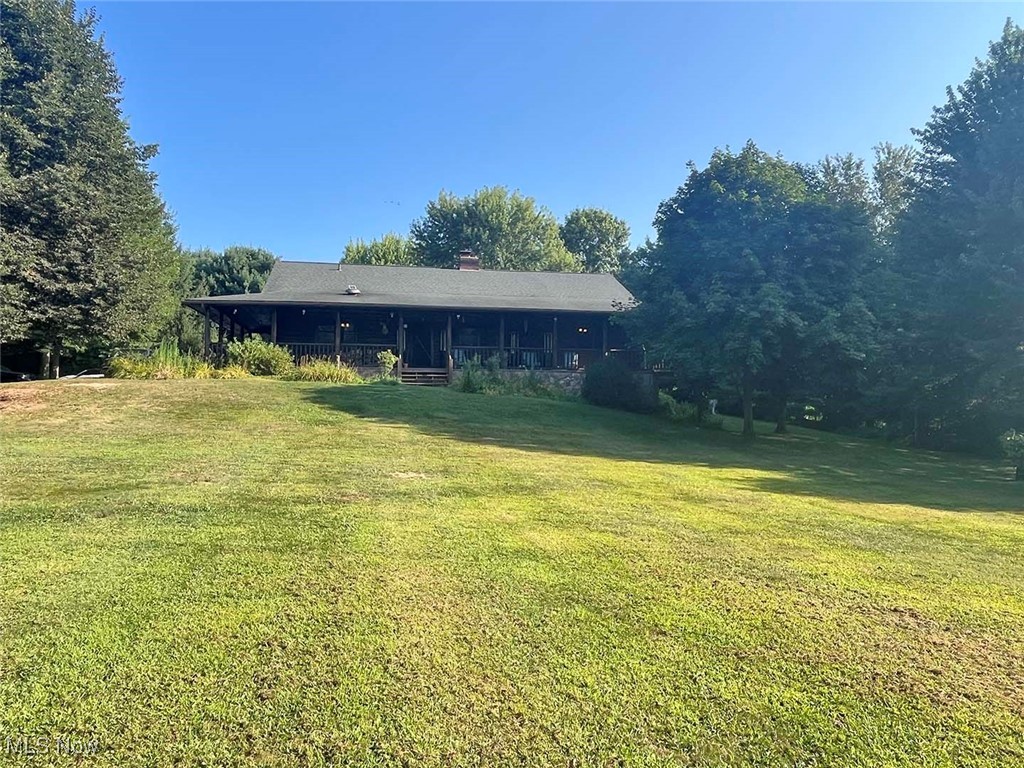 Opportunity knocking to own this beautiful and well-maintained log cabin-style home on 3.73 secluded acres. The home's features include a great room with vaulted ceilings and a double-sided stone fireplace, a kitchen with appliances, a dining area, and a living area that overlooks the private backyard. It has three bedrooms, two full bathrooms, a walk-in pantry, a first-floor laundry room, and easy garage access. The lower level offers one bedroom, two full bathrooms, a kitchen with appliances, a large living area, a laundry room, walk-out access, and ample storage. Additional features include 200-amp electric, a paved driveway, a wrap-around covered porch, a side patio, and a storage shed.
