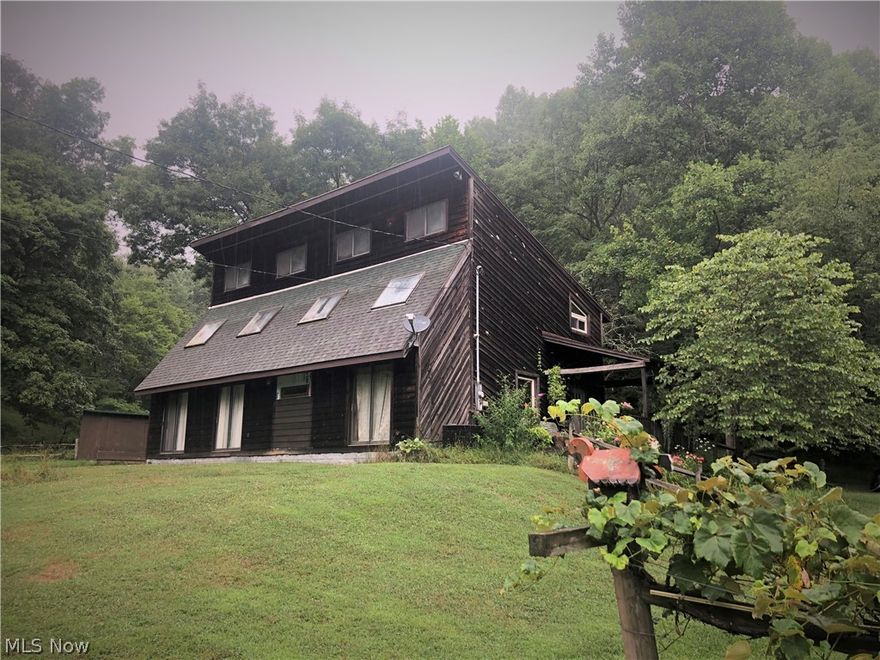 If privacy and country is what you are wanting then this is the home for you! This home is the next to last home on a dead end road.  Rustic double envelope home with so many unique features.  Beautiful wood beam in the living room, one of a kind carved wooden front door, gorgeous wood steps leading to the second floor.  This home offers a master bedroom on the main floor and plenty of living space with a family room, bedroom, and office that could easily be made a bedroom on the second floor. Sitting on roughly 25 acres with plenty of woods to explore, large garden area, grape vines, fenced (barbwire) in area for a small farm, chicken coop and a sense of peace.