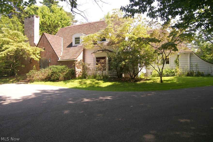 Elegant 1932 cape cod on over 6 rolling wooded & private acres near North Chagrin Reservation * 2 story great rm. Has 2 alcoves, one with bar area & WBFP * Master bedroom can be on either 1st or 2nd floor as each has a walk-in closet & one w/a fireplace * Kitchen w/pantry has newer s/s appliances  counter tops, 2nd sink, lots of cabinets w/roll out drawers & mobile lazy susan * 2 staircases* numerous closets & built-ins w/ample storage * 2 full baths 2nd flr* Walk-out bsmt w/half bath* Circular breakfast nook * Over 3000 sq ft w/3.5 season room* Two stone patios* 3 out buildings 1 of which is two car garage* 8/14 C. Tile roof tune up * Country setting w/amenities close by* Bring your personal touch to enhance the character of this unique home.