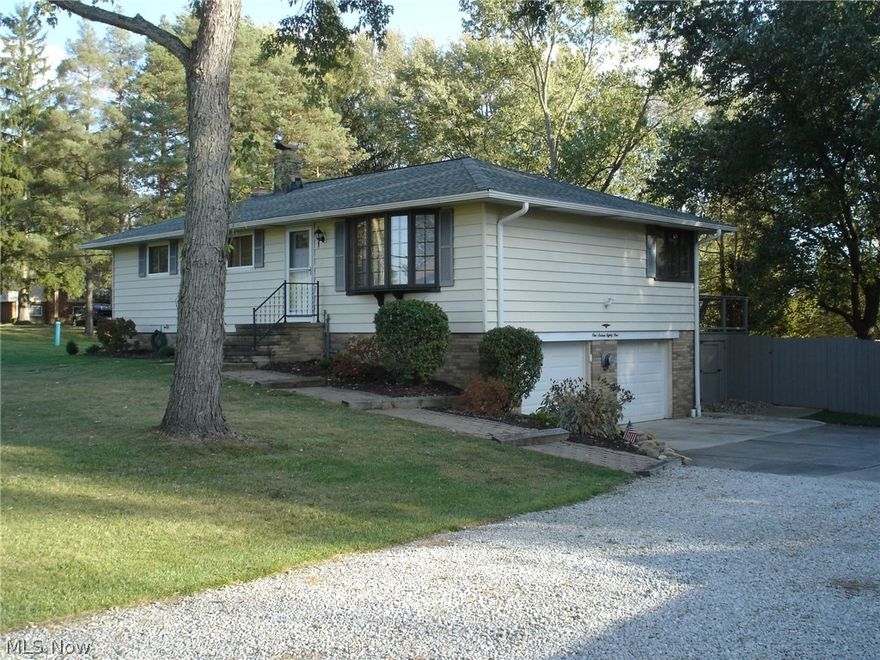 Natural light from the large window seat welcomes you into this spacious ranch home.  The large living room adjoins the dining area featuring a corner window overlooking the elevated deck and stamped patio. The updated kitchen offers quiet close cabinet doors and drawers, quartz countertops, stainless steel appliances, new flooring and fresh paint.  The main bath was just completed and is adjacent to three large bedrooms offering sparkling hardwood floors. A convenient half bath is of the main bedroom.  The lower level is finished and is the perfect place to entertain or just relax in front of the natural wood burning fireplace.  A drybar with wine cooler is great for setting the mood.  The entry to the heated garage is off the lower level and leads out to the parklike completely fenced back yard.  Enjoy time on the deck watching the world go by.  Every home has a story.  Begin yours here!