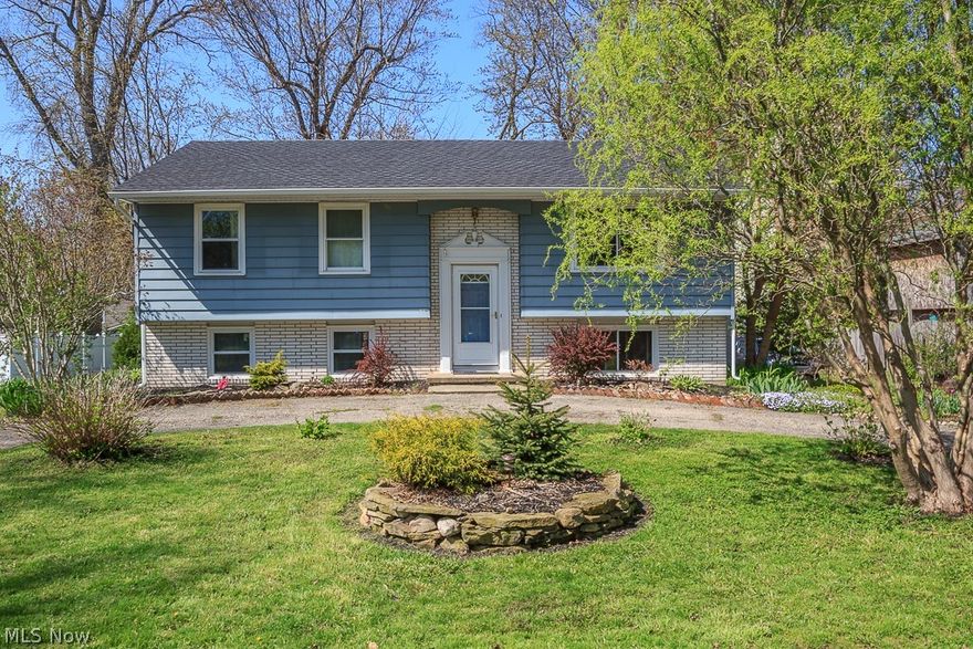 Inviting three bedroom, one and a half bath, bi-level home with horseshoe driveway and low maintenance landscaping! Upstairs features a living room with brick fireplace and laminate flooring. Updated kitchen with new tile backsplash, eat-in lunch top counter, pantry and open concept to the dining room. Three bedrooms and a full bath on the upper level as well. Downstairs features a cozy recreation room with a second brick fireplace as well as fresh paint and new tile flooring. The half bath downstairs is all new with a pedestal sink. There is also a huge laundry room and a storage room that could be finished into a 4th bedroom or extra living space. Access to the large 2 car garage in the basement. The outdoor living space including the large deck are accessible via a door in the kitchen. Listen to waves of the nearby lake as you roast marshmallows over the fire pit or do some planting in the raised garden beds. Other updates include energy efficient easy to clean windows, all flooring