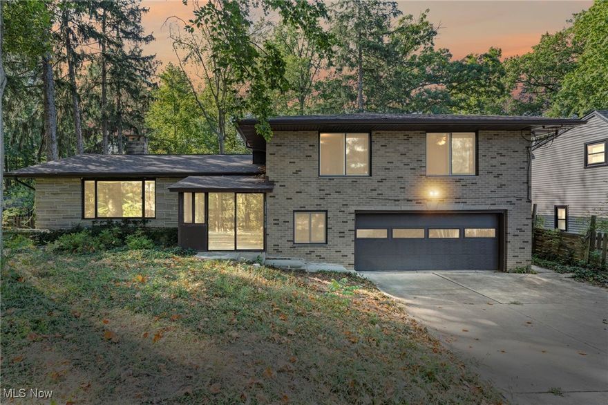 Welcome to this Classic Mid-Century Modern Split-Level from the 1960s! With over 2,500 finished square feet, this home offers an open floor plan in a prime Independence location — within walking distance to the schools, library, and recreation center. Step inside to the main family room with brand-new carpeting and a beautiful stone fireplace, seamlessly connected to the dining area — perfect for everyday living or entertaining. A bright and inviting sunroom overlooks the beautiful wooded lot, nearly a half acre, providing a peaceful retreat right at home. The adjoining kitchen features timeless quartz countertops, stylish subway tile backsplash, and all appliances — including double ovens. Upstairs, all bedrooms showcase the original hardwood floors and generous space. The primary suite offers a private bath and large closets, while all bathrooms have been recently updated with contemporary design touches, glass shower doors, and abundant storage. The lower level includes a spacious recreation room with a second stone fireplace and mantle, opening to a covered patio — ideal for gatherings or relaxing outdoors. You’ll also find an additional full bath and a flexible bonus room, perfect for a home office or guest suite. The attached two-car garage includes a large extra space with water access and a utility tub — perfect for gardening, outdoor projects, or washing up after yardwork. This well-maintained home features a new roof (2025), new electrical panels and outlets (2025), and includes a home warranty for peace of mind. The lower level adds nearly 1,000 square feet of versatile space with laundry and plenty of room for storage or hobbies. Come see this beautifully cared-for classic — combining timeless mid-century style, modern updates, and an unbeatable walkable location to parks, schools, and library!