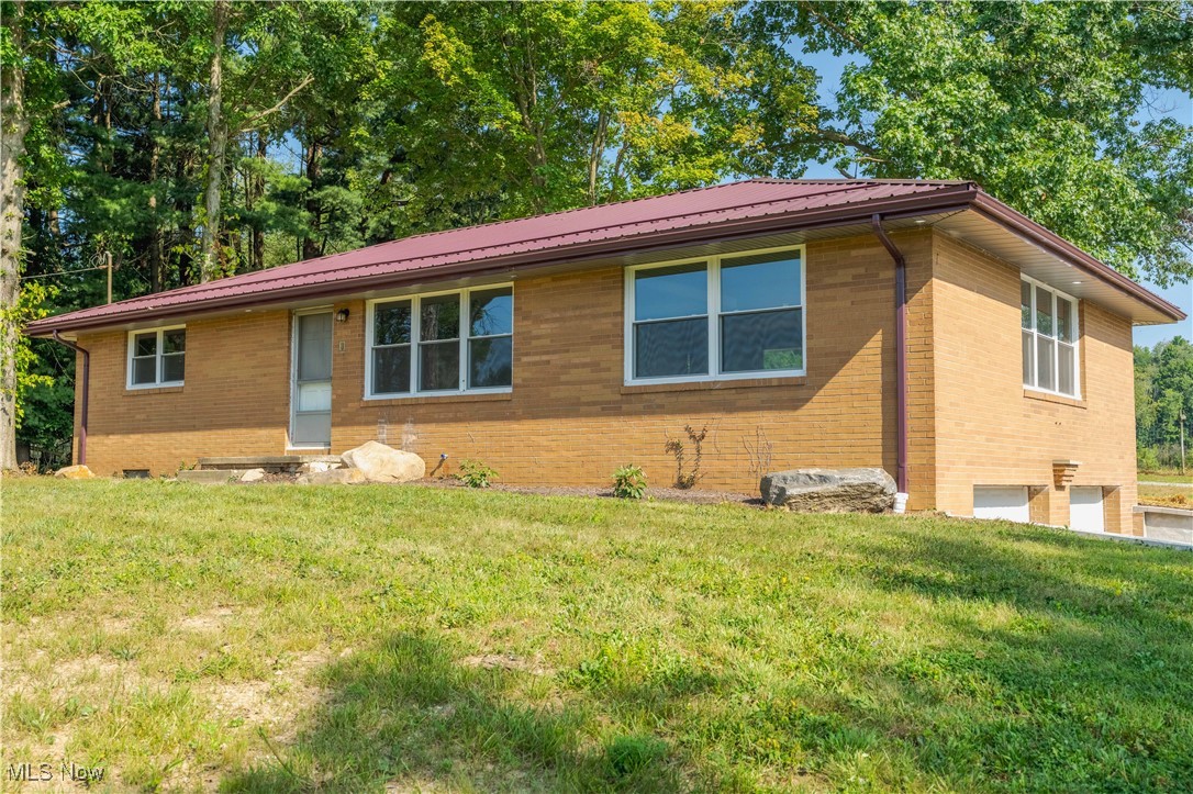 This beautifully updated brick ranch sits on 8.18 acres and offers over 2,100 sq ft of bright, airy living space. A gated, tree-lined driveway welcomes you into your private countryside retreat. Step inside to find a modern color palette, abundant natural light, and thoughtful updates throughout. The inviting front porch leads to the spacious great room, where two large picture windows frame serene views, and a modern ceiling fan adds style and comfort. The eat-in kitchen boasts rich cabinetry, butcher block countertops, an extra-deep sink, a stainless steel refrigerator, and picturesque backyard views, with access to the back porch. Outdoors, you’ll find a spacious yard with endless possibilities, featuring a pond with an island, a 40x32 outbuilding, a fenced area, and lush green space for recreation and relaxation. Two bedrooms and a full bath with a tub/shower combo, a new vanity, and a hallway linen closet are located off the main living area. A second full bath with a walk-in shower and a convenient laundry area completes the main level. The walk-out basement offers a vast recreation room, abundant storage, and access to the attached 2-car garage. Recent updates include a new roof and gutters, all new windows, garage doors, new masonry walls, new electric, plumbing, AC, furnace, hot water tank, insulation, water softener, new propane tank, added second full bath, new cabinets, light fixtures, first-floor laundry added, new countertops, and flooring. Schedule your private showing today and experience country living at its finest!
