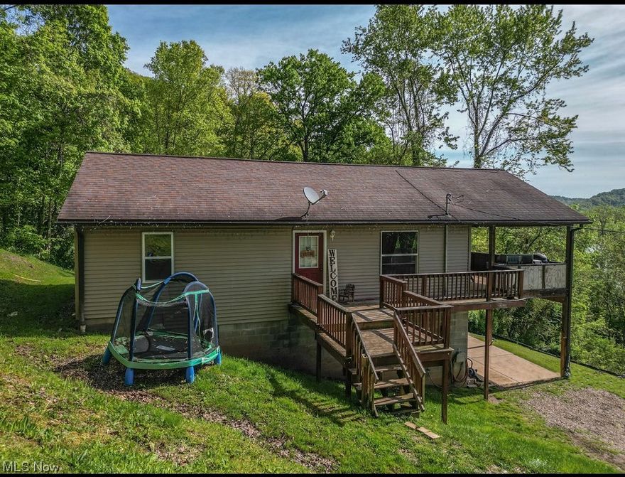 Don't miss out on your chance to own over 23 acres of prime hunting land in Washington County! Enjoy the privacy found as you're tucked away, high on the hill overlooking the Ohio River with wooded acreage that borders hundreds of acres of Wayne National Forest. This 2007 built 2 story home offers 2-3 bedrooms, 2 full baths, with a finished walkout basement. Open concept living, dining, and kitchen area are spacious and have sliders leading to a large covered front porch with the best views! The lower level offers a large, ceramic tiled family room and kitchenette and also has been vented for a wood stove. A 25x48 detached garage that has recently been insulated and heating added, great space for a workshop or for the mechanics out there. This property also includes an additional building along busy Rt. 7 that could be used for a business venture. It previously was used as a bait shop. To top it all off; there is also a small lot along the Ohio River.