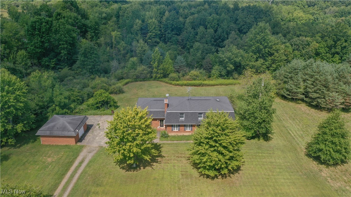 Discover the possibilities of this stately 4-bedroom, 3-bath, 3-car garage home in Western Reserve Schools, offering over 2,800 sq. ft. of living space on 8.46 acres of country living. With a mix of open yard and a wooded backdrop, the setting is both tranquil and picturesque—perfect for channeling your inner Chip and Joanna Gaines to reimagine, remodel, update, and add your own finishing touches. Step inside from the ceramic-tiled foyer into a formal living room, or enjoy the expansive family room featuring a decorative fireplace with a brick hearth and direct access to the kitchen and dinette. The kitchen offers an abundance of oak cabinetry, a corner sink, ceramic tile flooring, pantry with pullout shelving, and the dinette has access to the back patio through sliding glass doors. A formal dining room also overlooks the scenic backyard. The first floor includes a spacious bedroom conveniently located next to a full bath with tub/shower combo. Upstairs you’ll find three oversized bedrooms, including the owner’s suite with a double closet, a 5x10 walk-in closet, and private full bath. Another bedroom, with a double closet, provides access to storage above the garage. The 6-foot-wide hallway is lined with floor-to-ceiling bookshelves and leads to the 4th bedroom, also with a large double closet. There is another full bath on this level. The full basement offers even more space, and the property includes both a 2-car attached garage and a 1-car detached garage, plus a shed for extra storage. This home is being sold as-is and offers plenty of room to grow with endless potential. A new survey has already been completed, and both the well and septic inspections are done—making the process even smoother. Schedule your private tour today!