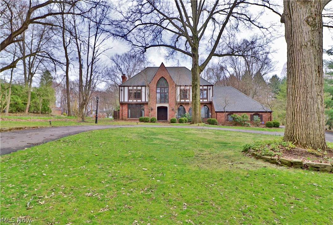 Fantastic setting on Ridgewood in desirable Fairlawn Heights! 5 bedrooms/3.2 bath Stately brick TUDOR with circular drive and large, level lot with gorgeous mature trees (2/3 acre). 4,000+ square feet plus lower level. Gracious entrance with two-story light-filled Foyer. 3 fireplaces, crown moldings, and extensive hardwood flooring! Spacious Living and Dining Rooms off of Foyer with wide entrances, tall windows and open feel. Updated gourmet Kitchen (Viking and Bosch appliances) with white cabinets and granite countertops. Tons of cabinetry especially with additional storage of the nearby wet bar. Kitchen opens to Sunroom overlooking deck and backyard. Inviting Library or Family Room with additional fireplace and gorgeous paneling. First Floor Laundry! Second floor light-filled landing leads to 5 bedrooms including Spacious Master Suite with dressing area and updated Bath. 4 additional bedrooms and 2 additional full baths complete the second floor. Lower level includes Rec Roo