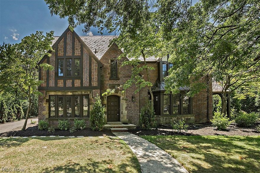 Tastefully preserving Shaker architectural charm while combining modern and elegant touches, this Tudor is completely renovated from top to bottom. Luxurious finishes create gracious living, starting with the open dining room and kitchen showcasing stainless steel Fisher Paykel DCS appliances, a wine cooler, gorgeous marble countertops, an abundance of cabinetry, and a center island. The formal living room is adorned with finely detailed crown molding and a lovely fireplace. Off the living room is an office with wood finishes and built-ins, as well as a bay window overlooking the backyard. A wrought-iron staircase leads you up to the master suite featuring a fireplace, walk-in closet with built-ins, as well as a a marble bathroom with glamour bathtub, double sinks, and a walk-in shower. Four more bedrooms, three bathrooms, and a laundry room can also be found on the second floor. The third level is incredibly spacious with cathedral ceilings and beams, making for an additional living s