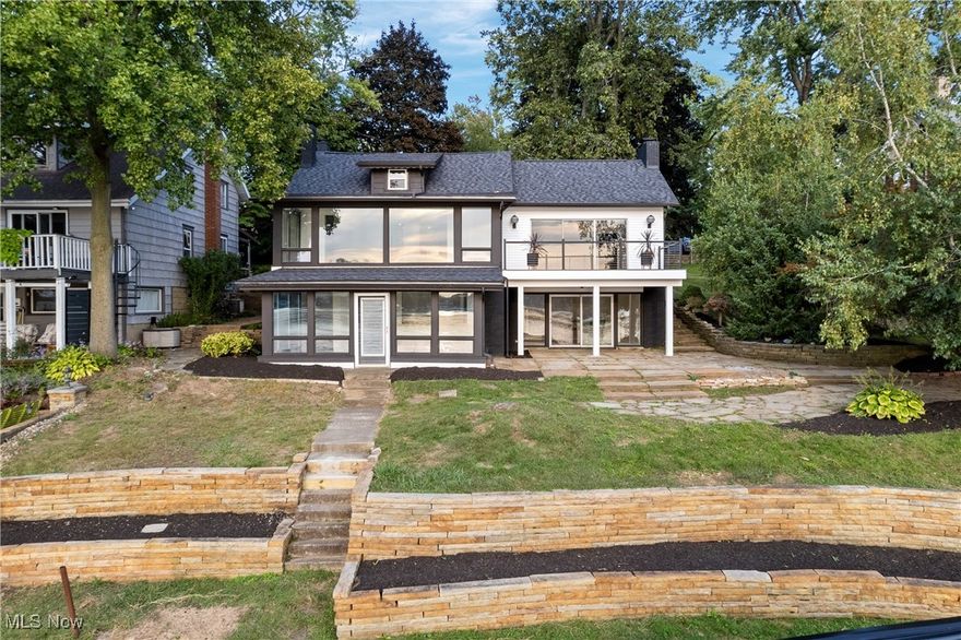 Looking for the “WOW” factor? You just found it. This stunning, fully remodeled lakefront home on the East Reservoir—part of the Main Chain of Portage Lakes—offers unbelievable panoramic sunset views and an unbeatable setting. Set on nearly half an acre, with 70 ft of lake frontage and a 352-foot deep lot, the home sits peacefully near the water’s edge, well away from the road, delivering both privacy and jaw-dropping scenery. Remodeled from top to bottom in 2024, 2025, this modern lake retreat blends comfort, style, and function. Fully finished walk-out lower level and an additional guest suite upstairs. The main living space is open and airy, with luxury vinyl plank flooring, plush new carpet, and a striking designer electric fireplace. Natural light floods through new windows and sliders, opening to a spacious composite deck where you can take in those iconic Portage Lakes sunsets. The kitchen is a true showpiece, featuring soft-close cabinetry, quartz countertops, and stainless steel appliances—perfect for entertaining or casual meals with a view. The oversized first-floor primary suite is a private sanctuary with its own deck access and a luxurious tiled shower in the ensuite bath. The finished walk-out lower level offers an additional bedroom, full bath, and a cozy family room with wood-beamed ceilings and walls of windows that bring the outdoors in. Just outside, your patio leads to a brand-new metal-covered boat dock with a covered slip—ready for summer fun and year-round beauty. Other standout features include a 2024 brand-new 35+ year architectural shingle roof, new siding. New 2025well oxygen injection purifying system, Chimney recently tuck pointed & painted Detached deep one-car garage, and generous parking space for all your guests. Every detail has been thoughtfully designed with a clean, contemporary aesthetic that feels both welcoming and refined. This one has it all—breathtaking views, privacy, and modern luxury in one unforgettable package.