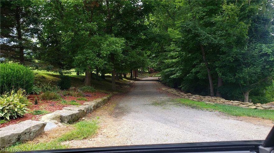 Enjoy the privacy of your new four season home hidden in the woods, surrounded by hundreds of acres of corn, soy bean, and hay fields. Just imagine the smell of that cut grass!
The seclusion is only interrupted by the sound of the animals in the back fields, the sound of the grass cutting on the golf course that is very nearby, the sound of the announcer and band at the high school football games.
A steady running stream flows along the edge of this property, made up predominantly of woods, making the cutting of grass minimal. OK, so you have leaves, but they make great mulch for your garden.
Your home was built by Amish craftsmen in 2002. In fact some of the wood was harvested right on the property. The entire home is made of wood, with the exception of the foundation walls. You will find no drywall/sheetrock. A true log cabin that when the sunlight hits the inside pine logs, they look golden.
Consistent with the insulation factor provided by logs, the home enjoys double roof insu