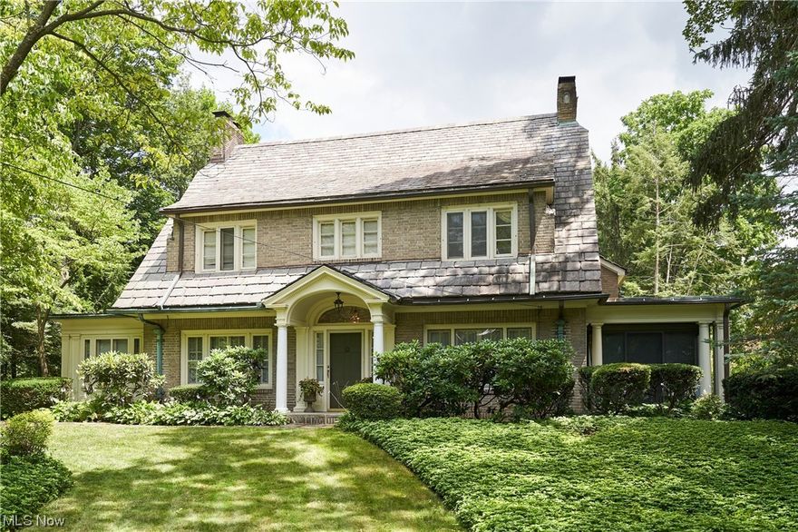 Incredible potential nestled between Portage Country Club and historic Stan Hywet. This center hall Colonial, built in 1921,  features all the classic details you'd expect from this era.    As you step inside, you’ll be enthralled by the stunning original details, including marble fireplace imported from England and plaster crown moldings. Intricate hardwood floors exude warmth and elegance, while two porches, one heated and one with sliding doors, bring the outdoors in. Main home includes vestibule with tile floor opening to Foyer with gracious staircase, Formal Living Room with French doors to enclosed side porch, and Dining Room with gorgeous moldings and French doors to Sunroom.  Kitchen includes Butler's Pantry with original cabinetry and sunny Breakfast Room.  In the rear, a Mudroom plus a Family Room addition adds fantastic casual living space and functionality.  Upstairs are 5 bedrooms plus 3 full baths including Primary Suite above Family Room addition. In addition to the main home is a charming carriage house which holds tremendous potential, perhaps as an apartment for guests or additional living space, and 3 garage spaces. The possibilities are endless, all on a generous 3/4-acre lot. Fully fenced backyard.  Slate roof, AC (approx 2012), Addition 1957. Don’t miss this opportunity to own a piece of history and create cherished memories in this exceptional property in a prime West Akron location. Call today to schedule a viewing and make 565 N Portage Path your own.