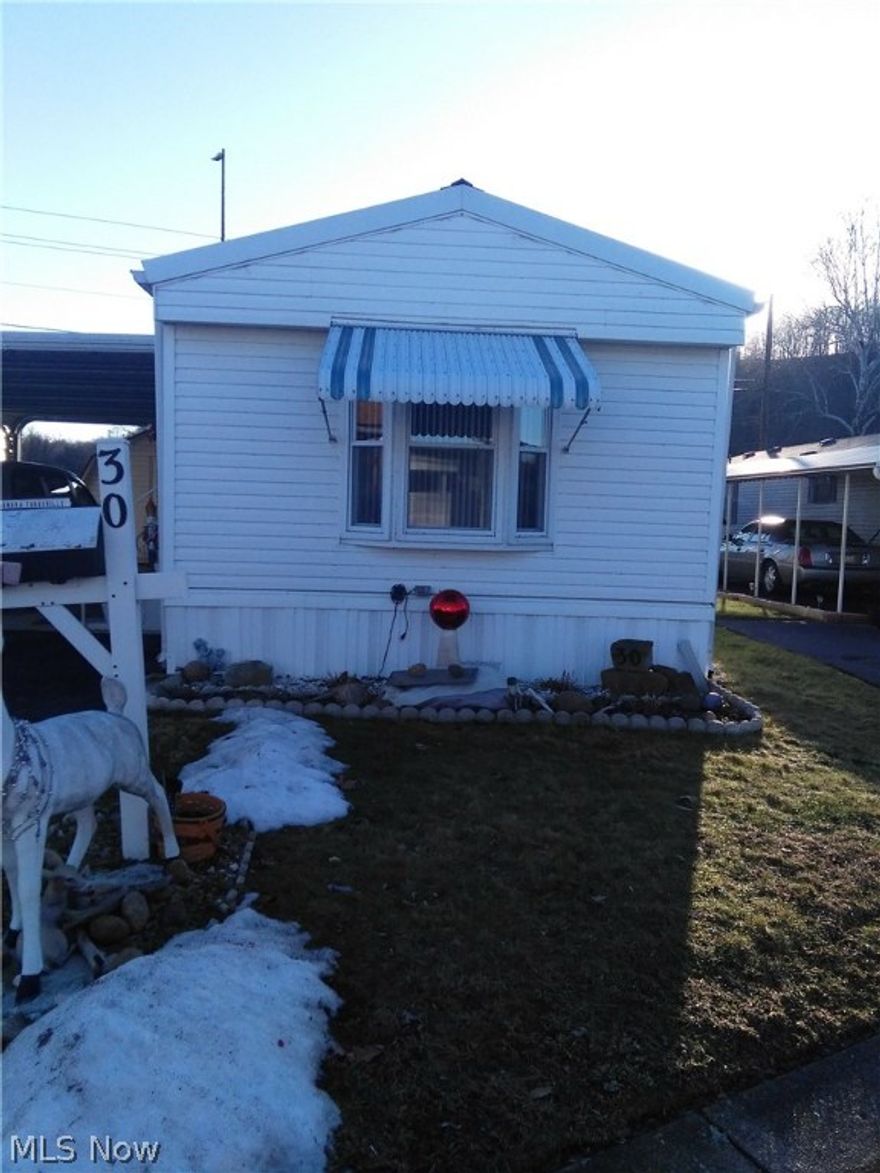 This Mobile home is located in Minn Lynn Mobile home park, a 50yr and over park. It has a paved entrance and drive with a lot rent of $175 a month. It has a 10x12 storage building with electric and a 2 car attached carport.  It has wood cupboards and vinyl tilt in windows. The bathroom has been updated with vanity and lighting.