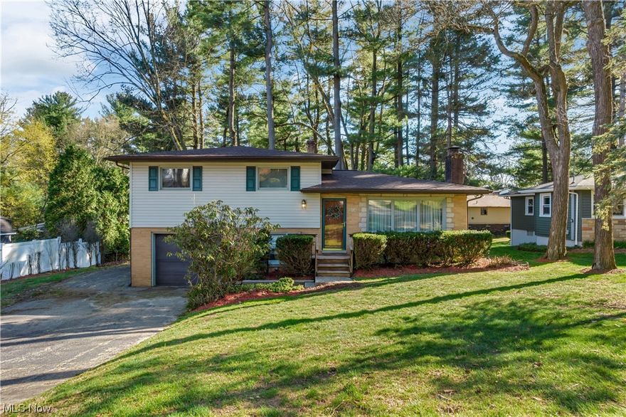 Check out this beautiful sprawling 4 level split-level home, located in highly sought after Turkeyfoot Heights in Green LSD! Situated on a large gorgeous wooded lot, you will love the covered porch and beautiful scenery in the back yard. The best part --  Big things have already been done! This 3-4 bedroom, 2 full bath home has a NEW roof with 30 year warranty, gutters, gutter guards (2023), NEW high efficiency Trane furnace/central A/C (2021) , NEW lighting in bedrooms & kitchen, and fresh drywall & paint throughout (2023). Large picture window and oak floors under carpet from staircase to hallway & in all bedrooms upstairs. Cherry cabinetry and tons of storage and built-ins in kitchen. 3 bedrooms upper/1 bonus bedroom OR office at garage entry level. Finished basement Rec room with fireplace and insert. On Public Sewer. Includes Turkeyfoot Heights PLX lake privileges and recreational facilities including community park with pavilion, playground, and tennis & basketball courts. Enjoy