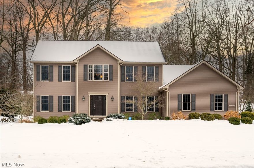 First time offered! Fall in love with this stately colonial nestled in one of Kent's best kept secrets and highly sought after University Woods! Situated on a generous 1/2 acre lot with a nice flat back yard, enjoy gorgeous wooded views year round from the amazing patio! Enter through the new custom front door into a 2 story foyer w/tiled porcelain flooring, 9 foot ceilings. Solid french doors lead to a first floor office/living room, featuring 3/4" hickory flooring and tray ceiling. The kitchen is a true gourmet's dream! Beautiful maple cabinets in rich cherry stain, 10 foot granite counter with seating for 5! Cook up a storm on the SS Fisher & Paykel 5 burner gas stove with a custom SS hood imported from Italy! Double oven w/convection and microwave, and a huge pantry with roll-out shelves! Open concept dining area flows into the great room with hickory flooring and stone front gas fireplace + a bright 4 season sun room! Kitchen/dining/foyer/sun room all have porcelain flooring! The