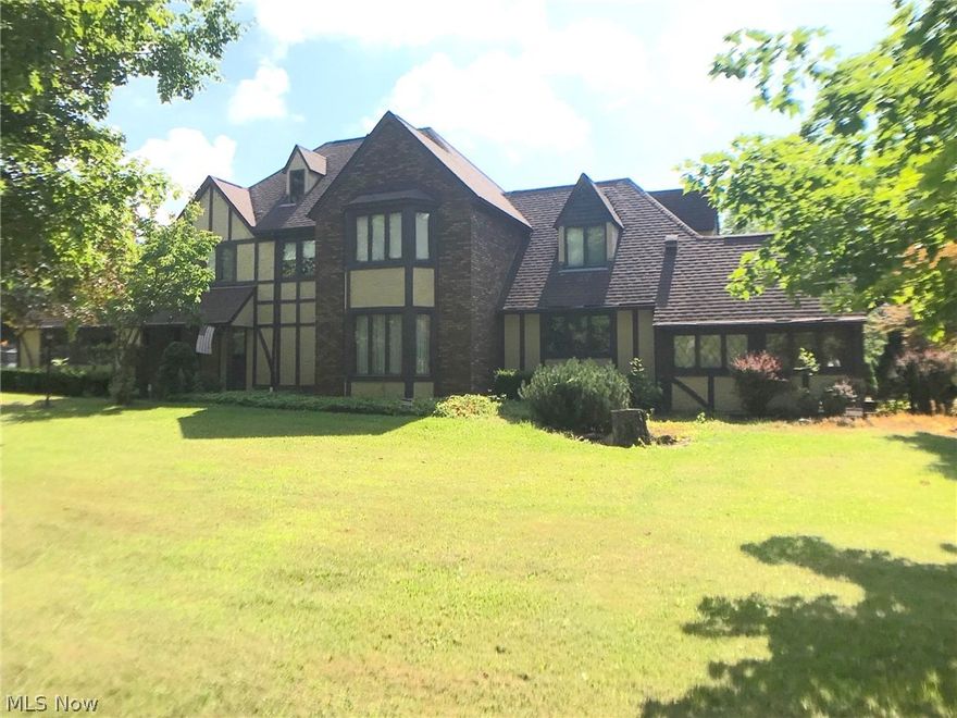 This is a 2935 sq. ft. true classic upscale 4 bedroom Tudor house (5th BR possible in Office area on 1st floor) with 1604 sq. ft. full basement on 2.3 acres of land with some mature trees. There are master craftsman designed oak and cherry paneled walls through out the house, with hardwood floors and some ceramic floors. There are 2 large full baths on the second floor and 2 half baths on the first floor.  The eat-in kitchen has a separate breakfast nook with a stone planter.  There is a whole house vac system, a security systems and an intercom system.  New roof shingles were installed in 2008. A concrete drive curves in front of the house to the attached 2 car garage. There is a first floor laundry area off of the kitchen.  There is a wet bar with leaded glass doors in the family room.  Leaded glass French doors separate the formal dining room area from the family room.  In the basement there is a door with stairs to the outside, and there is another wood burning fireplace with sands