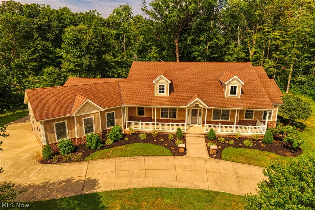 Quality custom built ranch on 1.8 wooded acres! Located across the street from Liberty Park, this beautiful home offers great living space as well as awesome outdoor amenities including large covered patio overlooking wooded rear yard, full front porch to enjoy the view, attached two car plus separate attached one car garage as well as an outbuilding with full garage door (great for craftsman or collector)! Hardwood floors throughout foyer, halls, kitchen, pantry & sun room. Spacious kitchen features granite counters, expansive island, walk-in pantry with second refrigerator, double wall ovens & plenty of counter and cabinet space! Delightful sun room off kitchen leads to covered patio for easy entertaining. Great room features gas fireplace with feature lighting and access to patio. Owner's suite offers french door to patio, 13 X 12 bath with shower stall plus soak tub plus 10 X 6 walk in closet! Basement features finished rec room with wet bar and full bath, unfinished area with wood