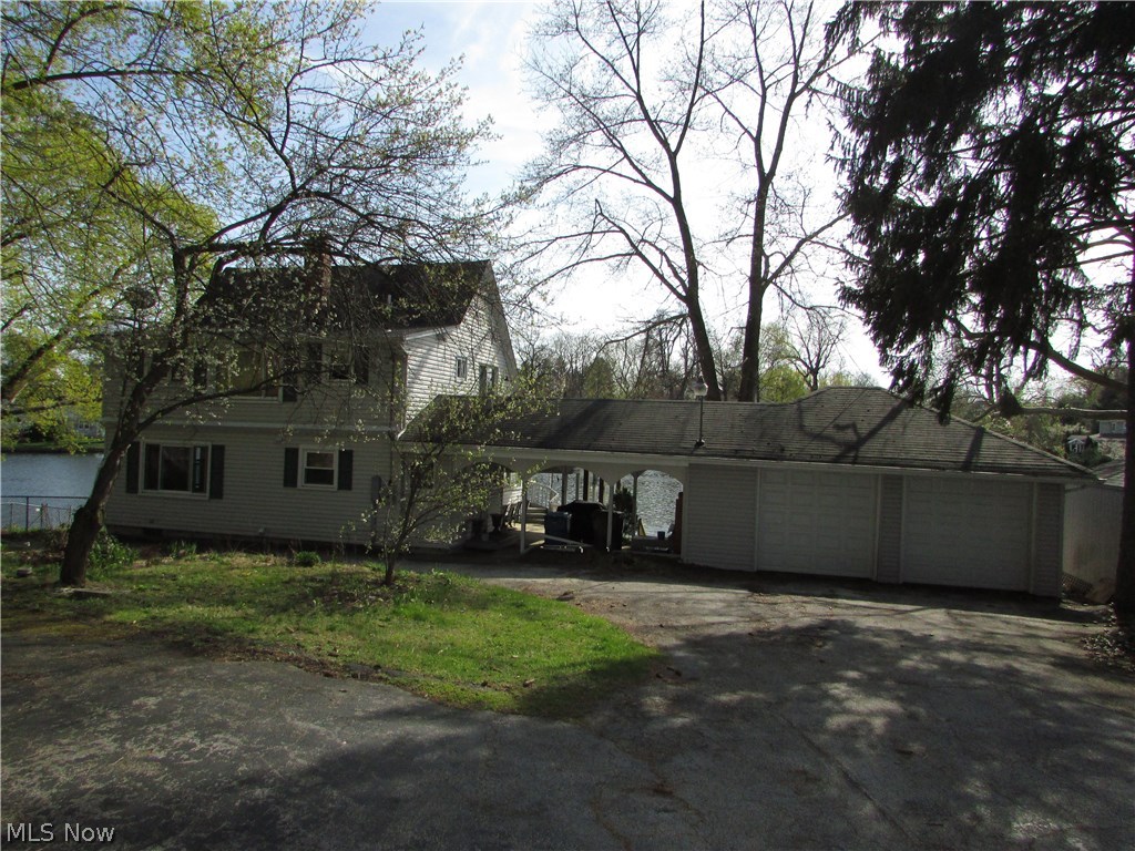 Wow!! Over half an acre with 140' of water frontage on the main channel of the West Reservoir. This updated home has a deck over the water, walk out basement, and additional docs for boats, jet ski's, kayak's... you name it. A 2 car garage is attached with cover. A circular driveway, plus additional parking make this home so easy to entertain. The master bedroom walks out to an additional deck to enjoy the water views. An eat-in kitchen, and large living room, share a rear wall of windows with amazing views. This home is very near restaurants/nightlife on the water, Turkeyfoot Golf Club, and so much more. A full basement, second floor laundry, outbuilding, and mud room are just some of the many amenities.