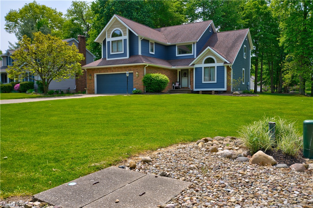 This beautiful home is located in a quiet neighborhood in the Revere School District. It has a spacious open floor plan, many updates, and a picturesque wooded lot. The entryway welcomes you with a two-story foyer. The living room has a towering vaulted ceiling and a large Palladian window overlooking the lawn. The formal dining room has crown molding. The kitchen is spacious and updated, with plenty of cabinets, granite countertops, and a center island, newer appliances, and a desk/serving area. Lots of natural light and slider to a private deck. The family room is open to the kitchen and has a brick wall gas fireplace surrounded by built-in cabinets. The main level also includes a large laundry room. The second level has four bedrooms, including a master retreat with vaulted ceilings and two walk-in closets. The bright glamour bathroom has vaulted ceilings, a gorgeous window, dual vanities, a garden tub, and a shower. The full basement is partially finished and provides an additional