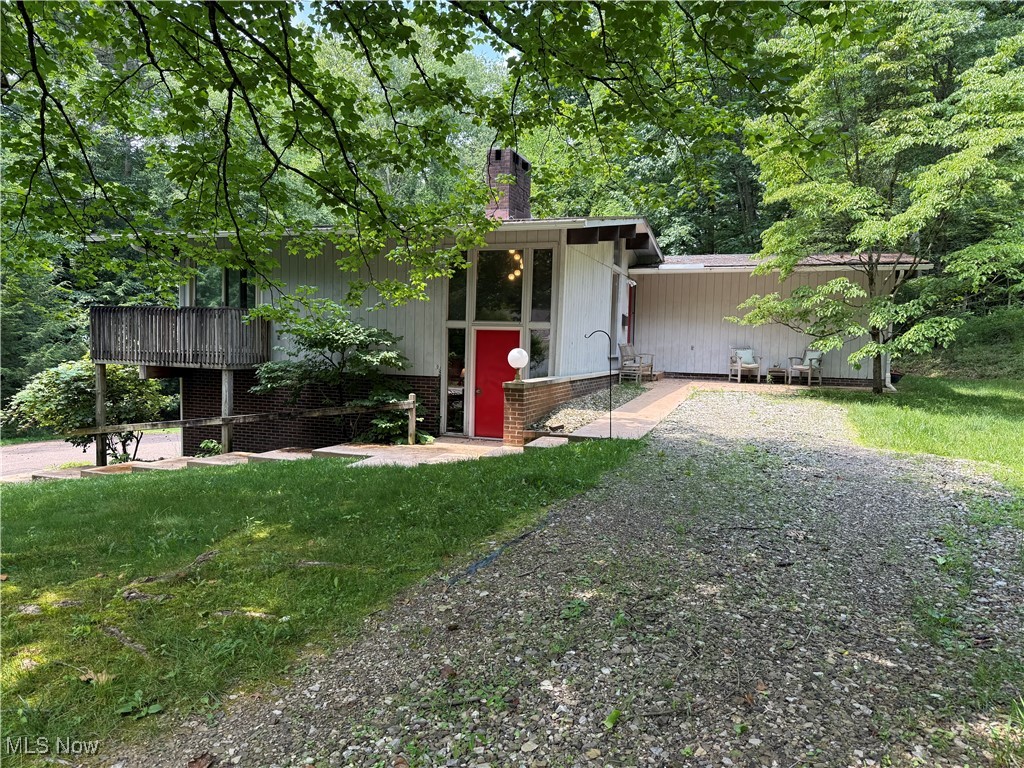Located in an area of town that few even know exists, resides this 3BR-2.5 BA Mid-Century Modern style home on 3.57 acres. Upon entering the slate tile floor will lead you up to the first level. A spacious great room with a floor to ceiling fireplace leads to the dining area, both with a full wall of windows overlooking the woods. Tucked around the corner is the fully equipped eat in kitchen with nice cabinetry. Head on back the hall and you will find 3 nice sized bedrooms with full walls of closets, and a full bath with an adjoining half bath with a stacked washer/dryer. Meander back down to the lower level which contains the 2-car garage, a workshop area and a large family room with a freestanding wood stove. There is also an indoor grill/bar area with a sink perfect for entertaining. Lead on and you will find another laundry/storage room with the 3rd bathroom. In town, secluded location, minimal yard upkeep, on 3.57 acres, check this one out!